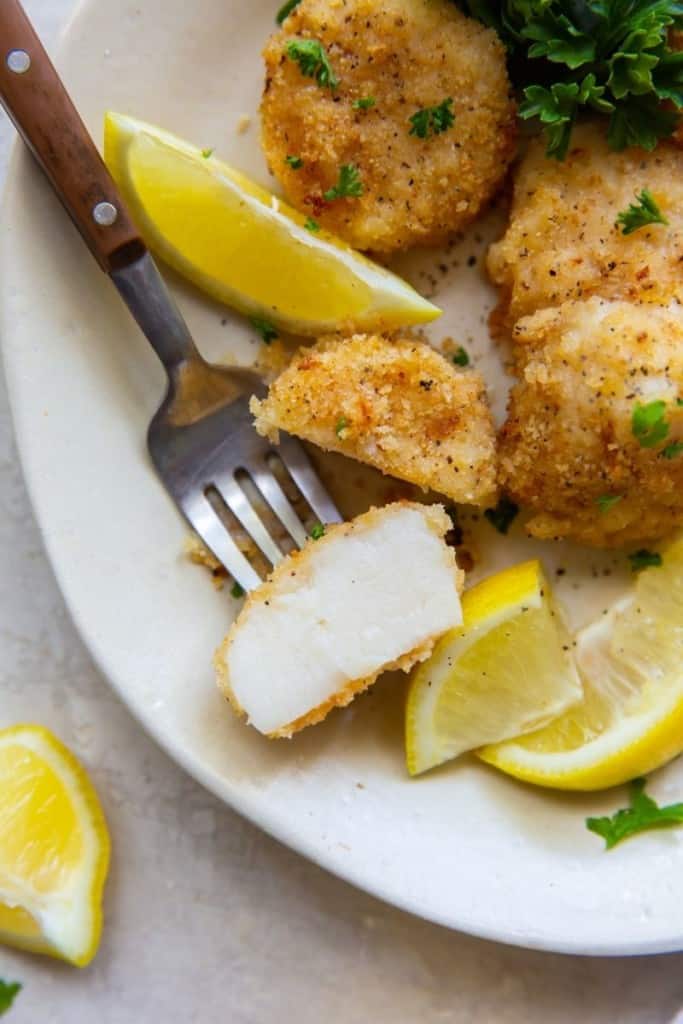 Closeup of scallops with inside showing and lemon slices around them