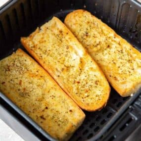 3 halves of garlic bread inside the air fryer cooked