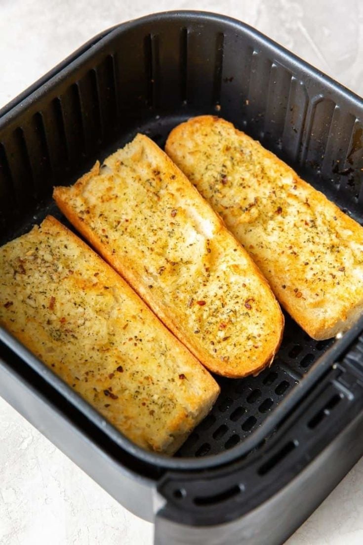 3 halves of garlic bread inside the air fryer cooked