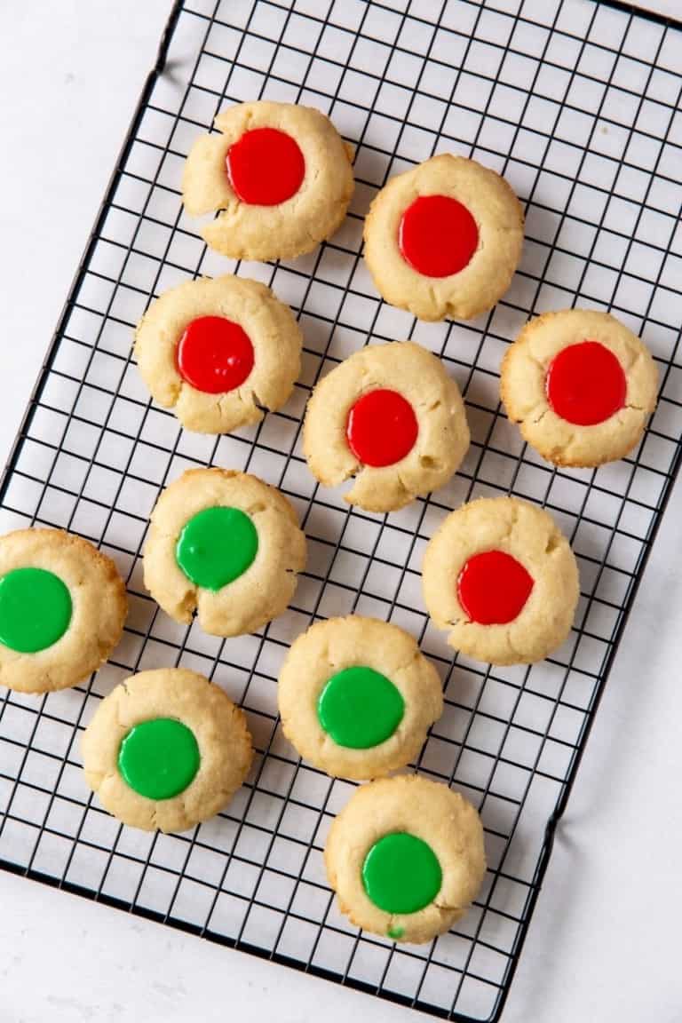 Iced Thumbprint Cookies with red and green icing on a cooling rack