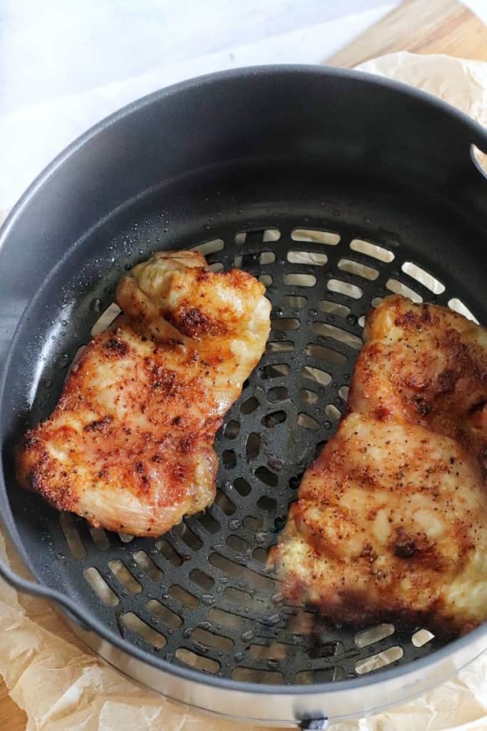 Chicken thighs in ninja foodi basket partially cooked before BBQ sauce is added