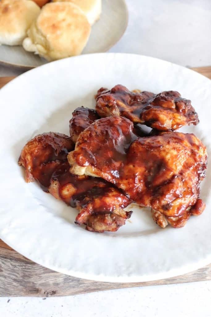 BBQ chicken thighs on a white plate