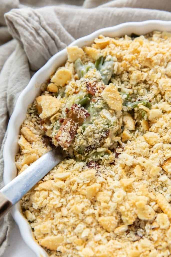 Green Bean Casserole in a round casserole dish with a serving spoon inside