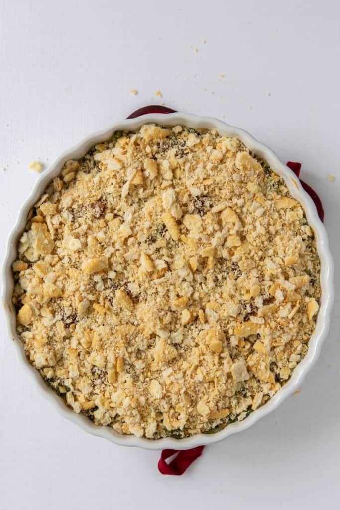 Green Bean Casserole with ritz crackers on top in a round casserole dish