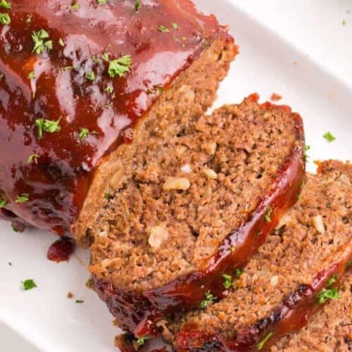 Air Fryer Meatloaf on a white serving tray with half sliced