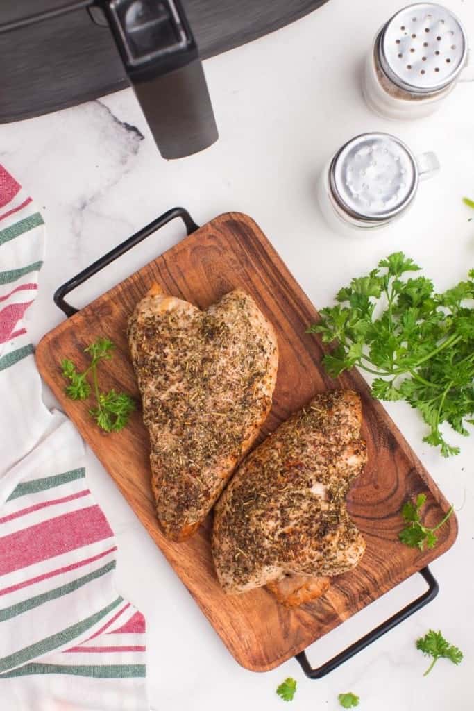 Cooked full air fryer turkey tenderloins on a wooden serving tray