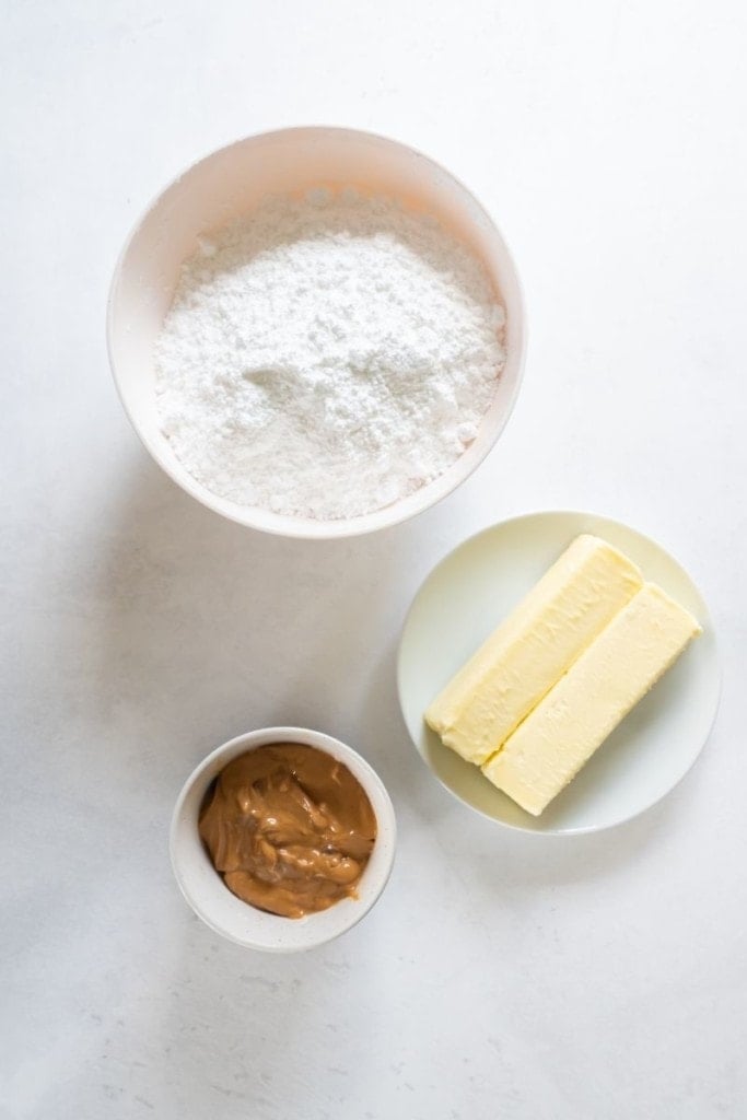 Ingredients needed to make peanut butter frosting in separate bowls