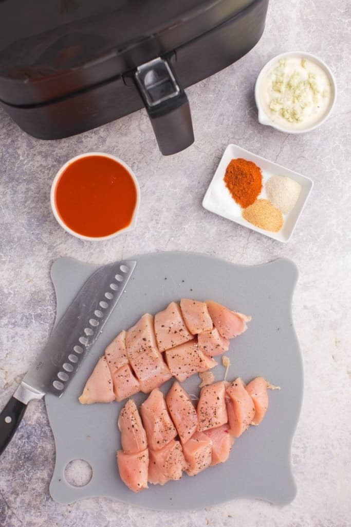 Chicken chopped up on a grey cutting board