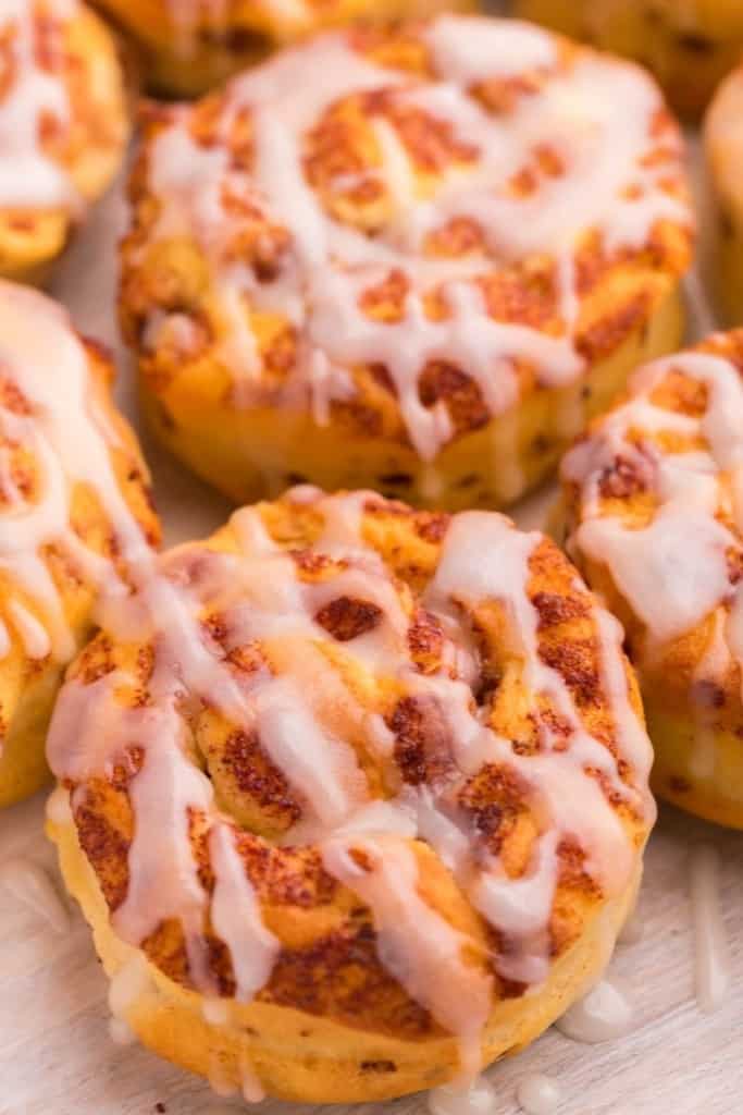 Closeup of air fryer cinnamon rolls topped with icing