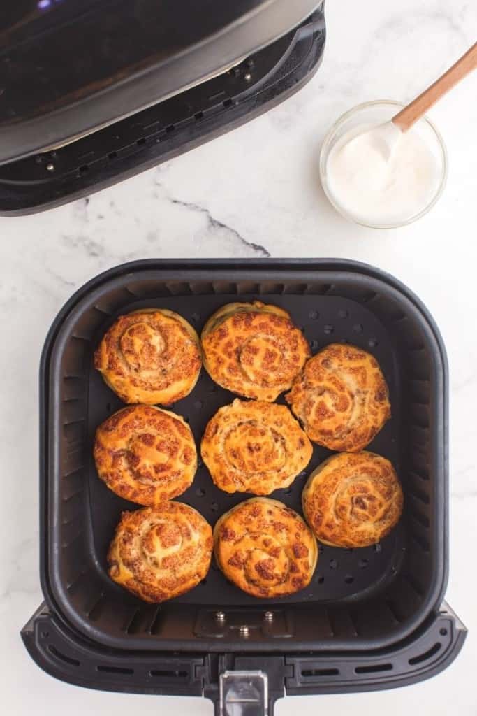 Cooked cinnamon rolls in air fryer basket