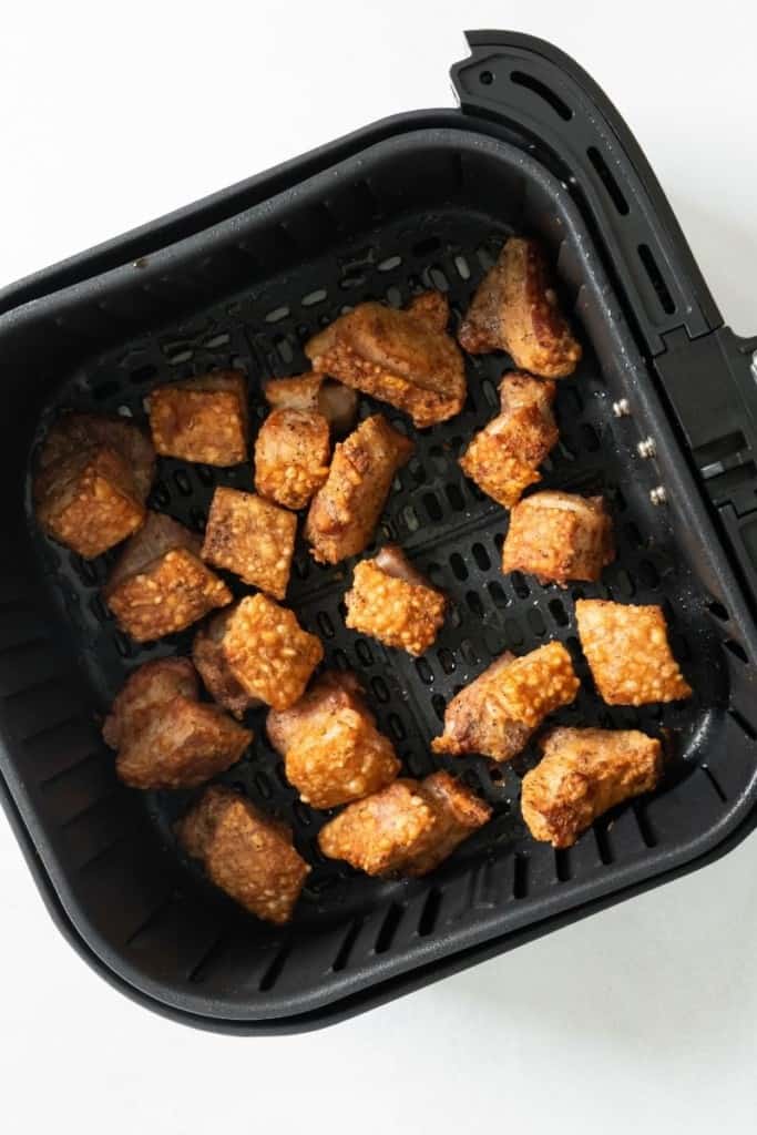 Cooked crispy pork belly in air fryer basket