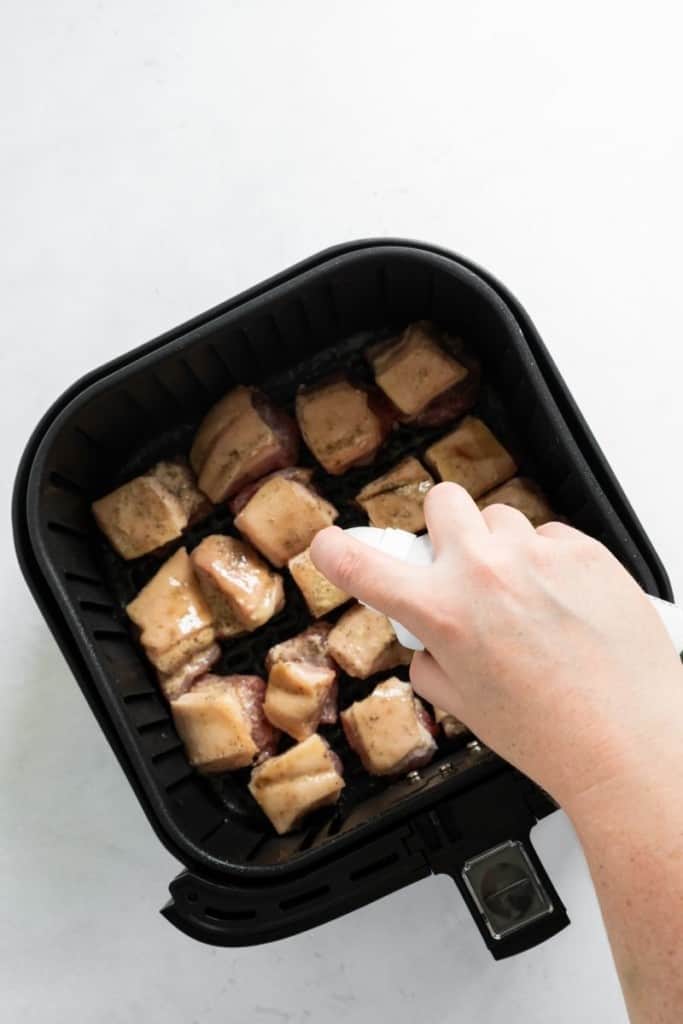 Pork Belly being sprayed with oil in the air fryer