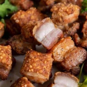 Closeup of crispy pork belly pieces served on a plate