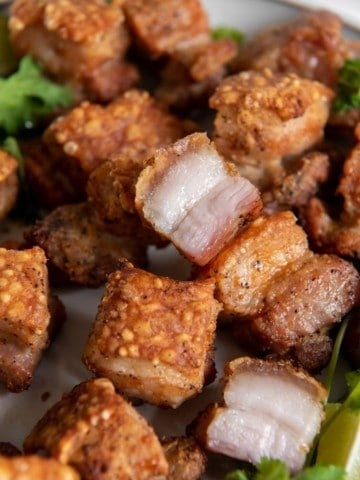 Closeup of crispy pork belly pieces served on a plate