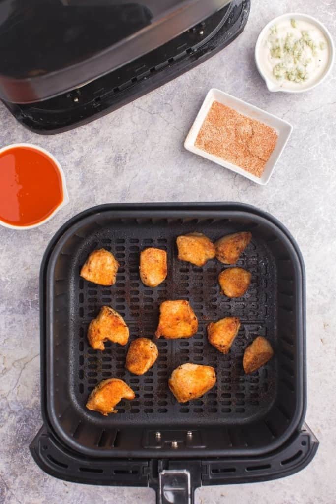 Cooked boneless wings in air fryer basket