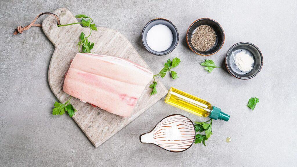 Ingredients needed to air fry pork belly: pork belly, salt, pepper, baking powder, garlic powder, and oil.