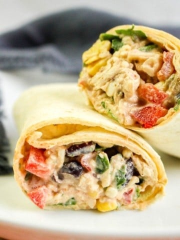 Southwest Chicken Wraps cut in half on a white plate and leaned on top of each other