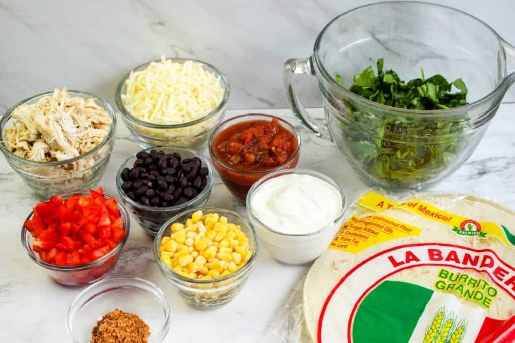 Ingredients needed to make southwestern chicken wraps in separate bowls