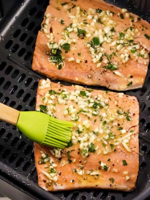 Air Fryer Salmon being basted by a silicone baster as an air fryer accessory