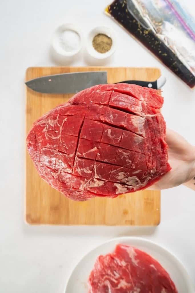 score the raw steak in a crisscross pattern