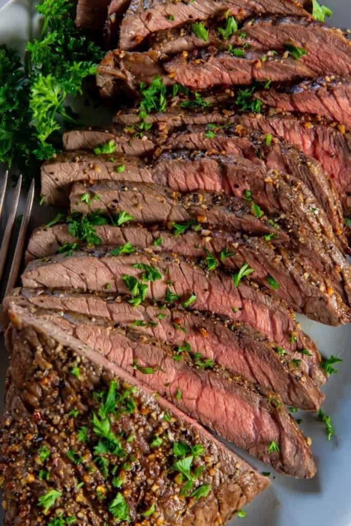 Closeup of sliced London Broil topped with parsley