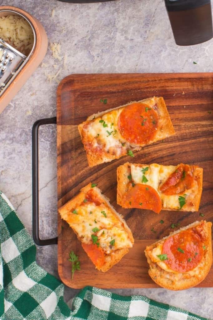 french bread pizza in air fryer displayed on a cutting board