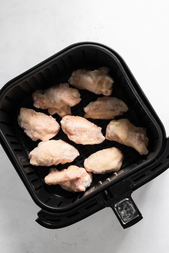 Frozen chicken wings in air fryer basket