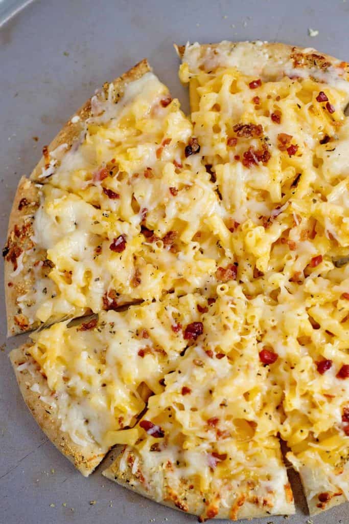 Macaroni and cheese pizza sliced in a circle made with leftover mac and cheese
