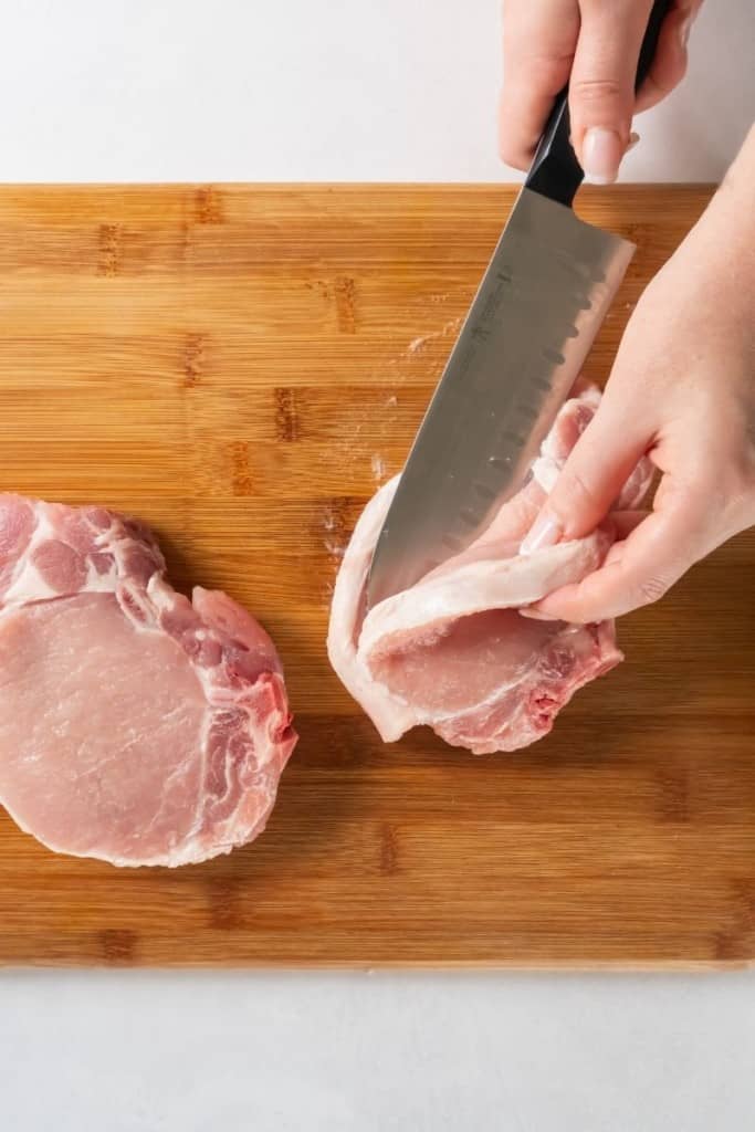Pork Chops being sliced in the middle to create stuffed pork chops