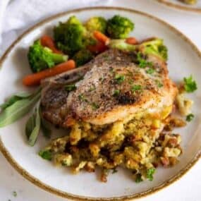 Air Fryer Stuffed Pork Chops on a plate with veggies on the side.