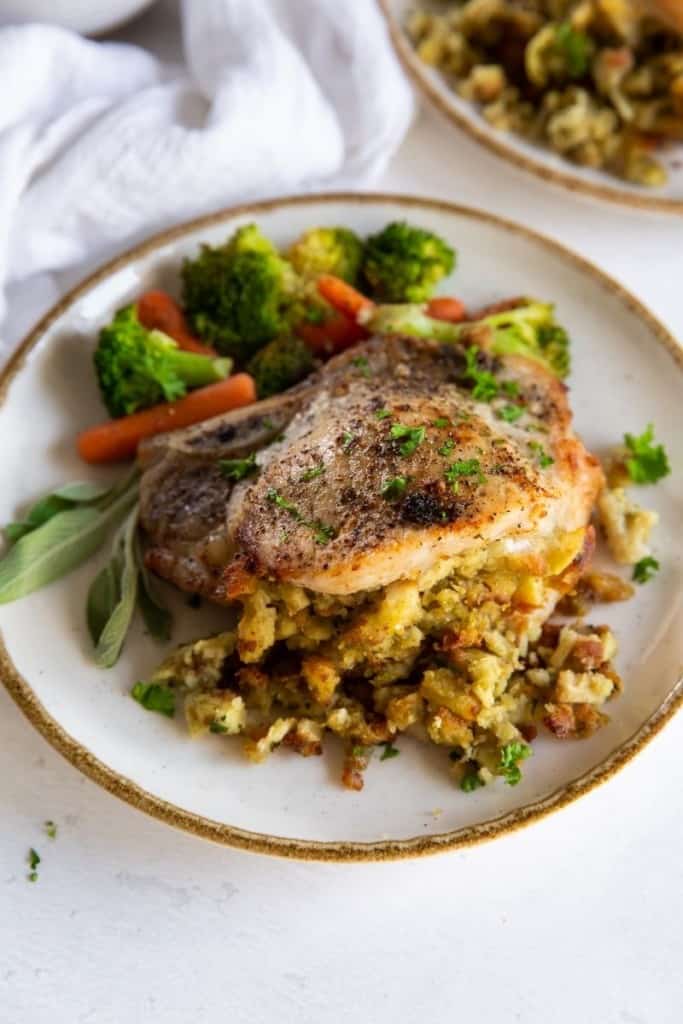 Air Fryer Stuffed Pork Chops on a plate with veggies on the side.