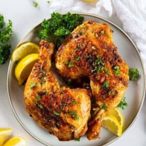 Air fryer chicken leg quarters with lemons on the side