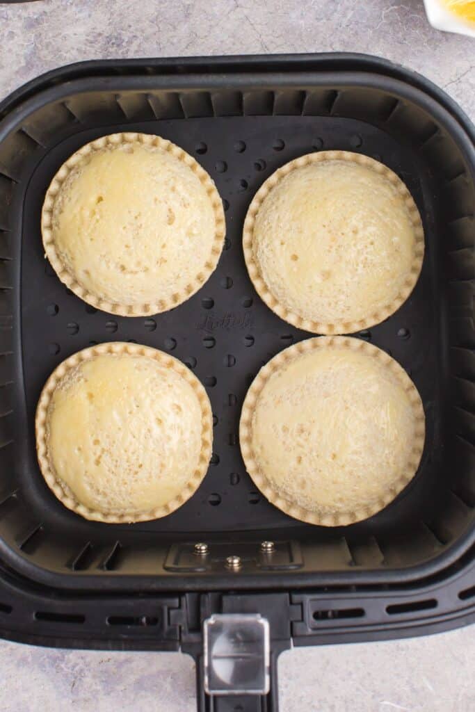 Frozen uncrustables in the air fryer basket about to be air fried.