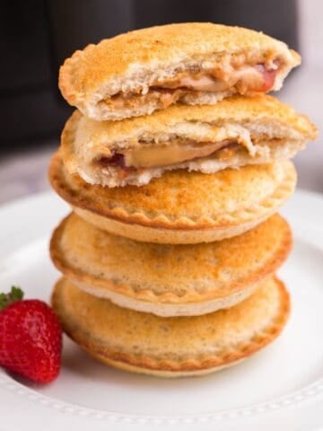 Stacked air fryer Uncrustables on top of each other with the top one split in half.