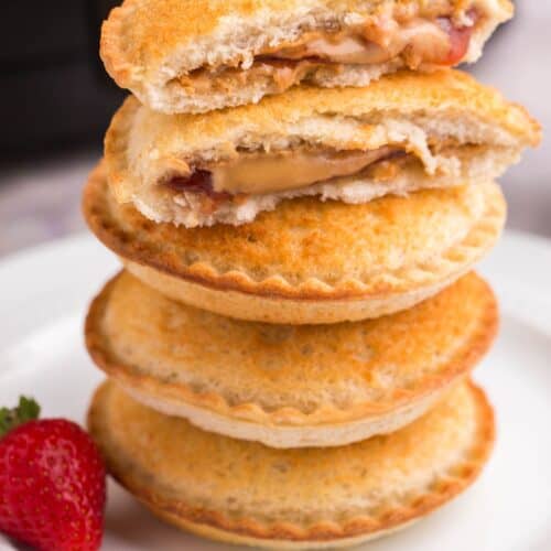 Stacked air fryer Uncrustables on top of each other with the top one split in half.