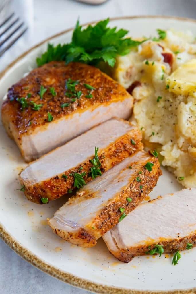 sliced pork chops on plate with garnish