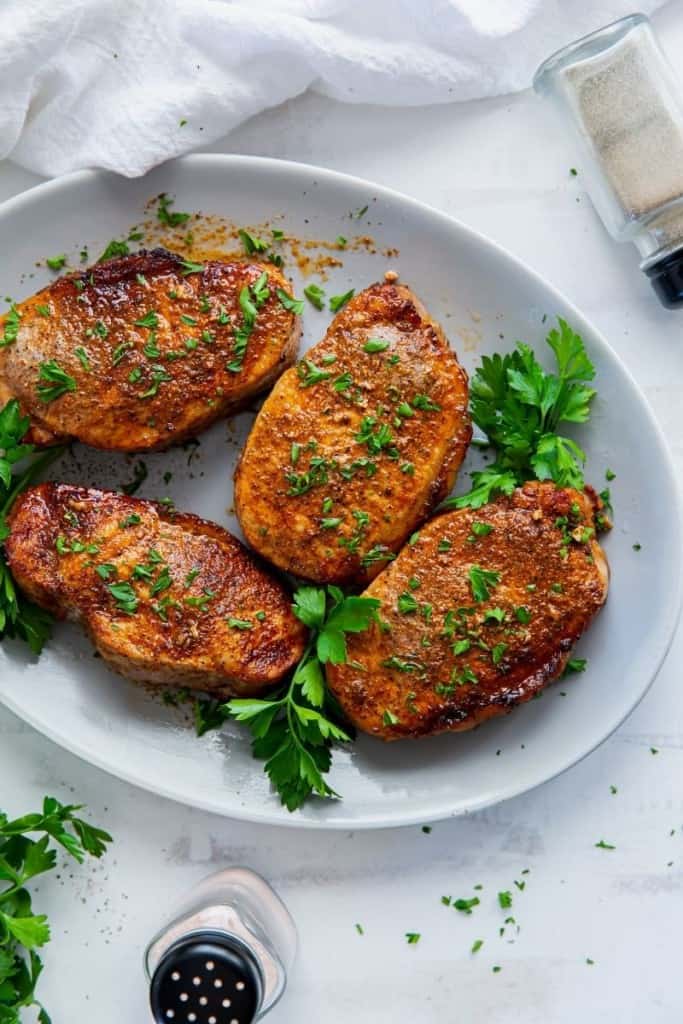 finished pork chops on plate with garnish