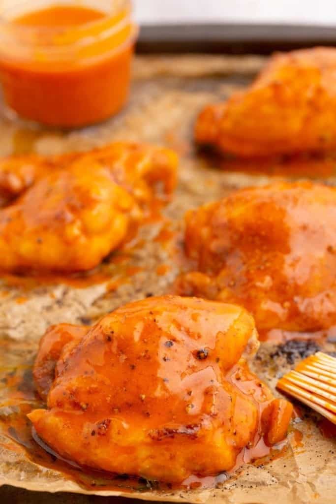 spicy buffalo sauce basted on chicken thighs