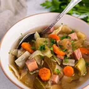 Crockpot ham and cabbage soup in a white bowl