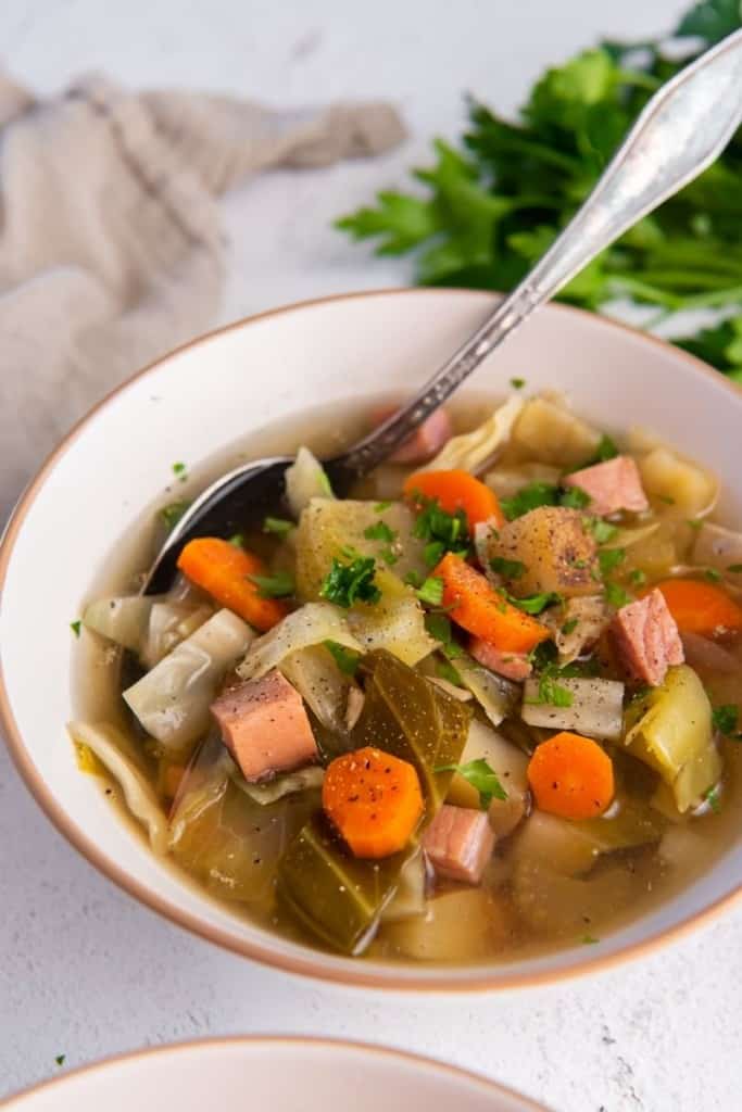 Crockpot ham and cabbage soup in a white bowl