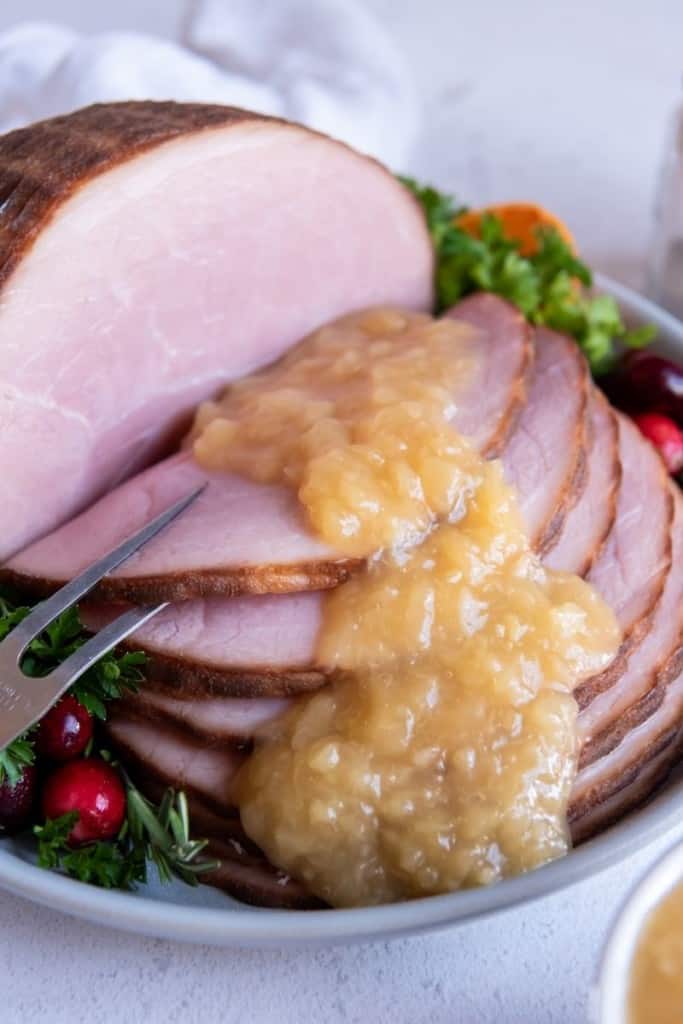sliced instant pot ham on plate with gravy