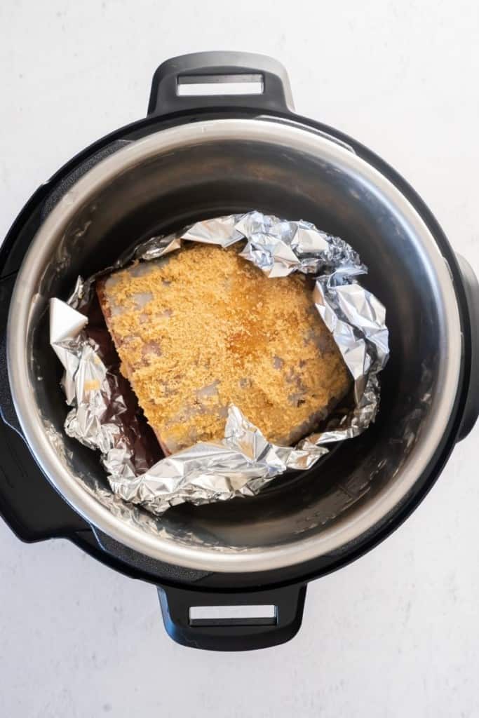 wrap ham in aluminum foil and drizzle brown sugar glaze