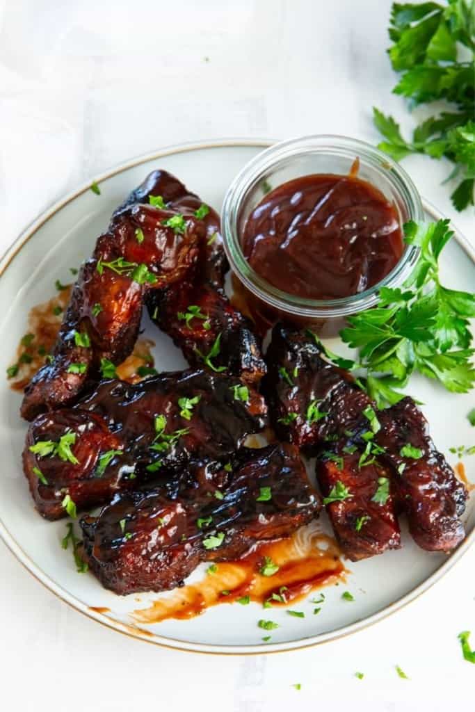 Ribs reheated in air fryer on a plate with dipping sauce