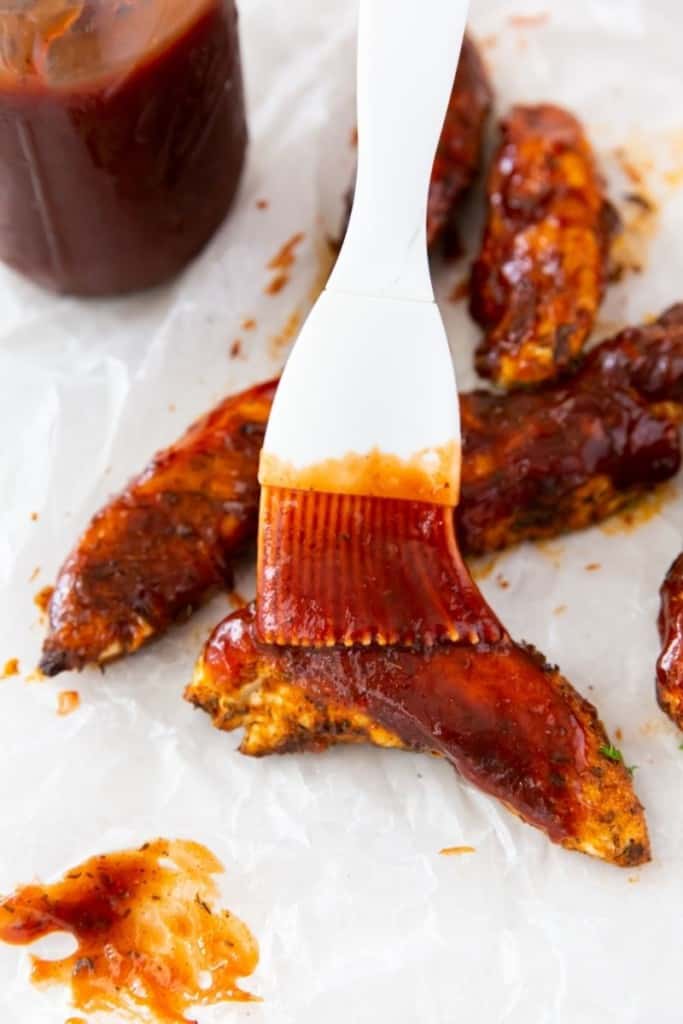 2 ingredient BBQ sauce being spread on chicken tenders