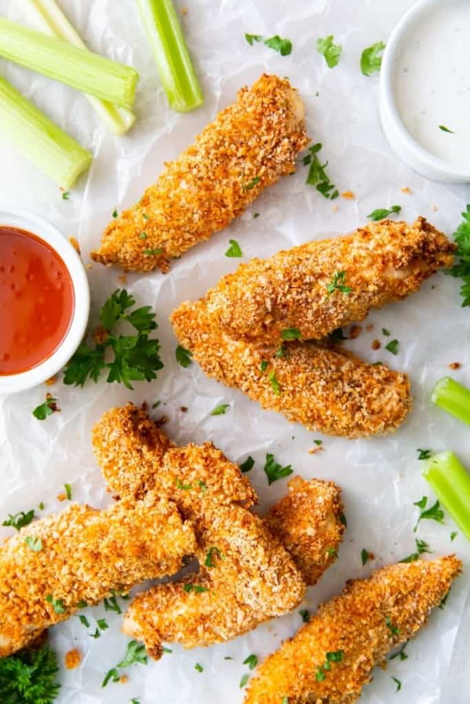 buffalo chicken tenders placed around buffalo sauce for dipping