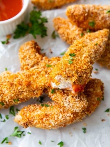 Several air fryer buffalo chicken tenders with one bitten into