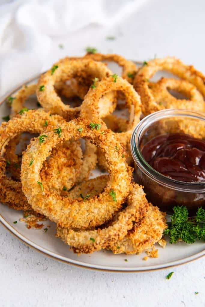 plate full of air fryer onion rings with dipping sauce