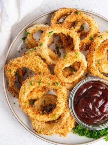 air fryer onion rings on plate with dipping sauce on the side