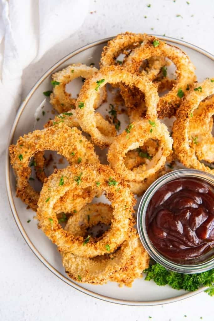 air fryer onion rings on plate with dipping sauce on the side
