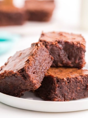Three fudgy brownies without cocoa powder on plate